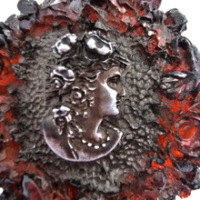 Load image into Gallery viewer, Flacon ancien en bakélite rouge ambré et médaillons argentés à décor de roses et profil féminin, vers 1920-1930 Le Charme des Violettes - Brocante en ligne