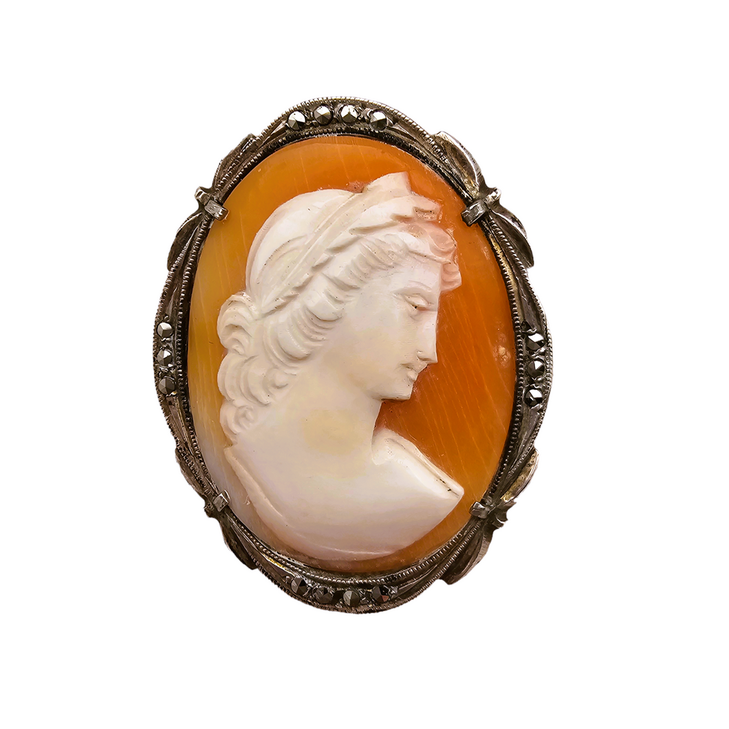 Shell cameo pendant brooch representing the God Apollo with laureate head, in an 800/1000 silver setting set with marcasites, early 20th century