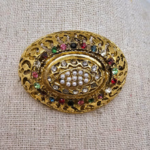 Charger l&#39;image dans la galerie, Broche vintage bombée en laiton doré ajouré, décor de strass multicolores et de perles (imitation), années 1950
