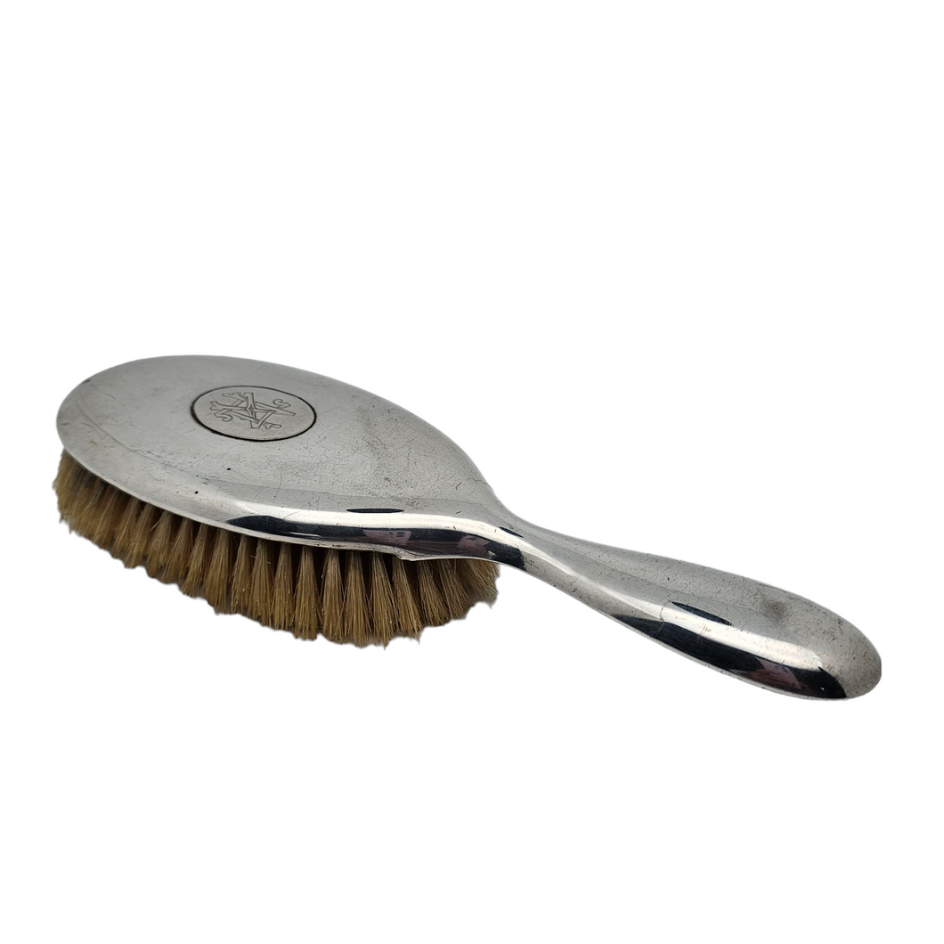Old hairbrush in monogrammed silver metal and natural bristles
