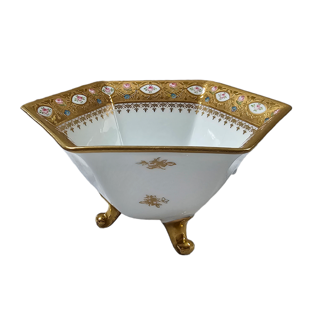 Sèvres (dans le goût de). Coupe tripode en porcelaine blanche bordée d'une frise d'or et de petites roses